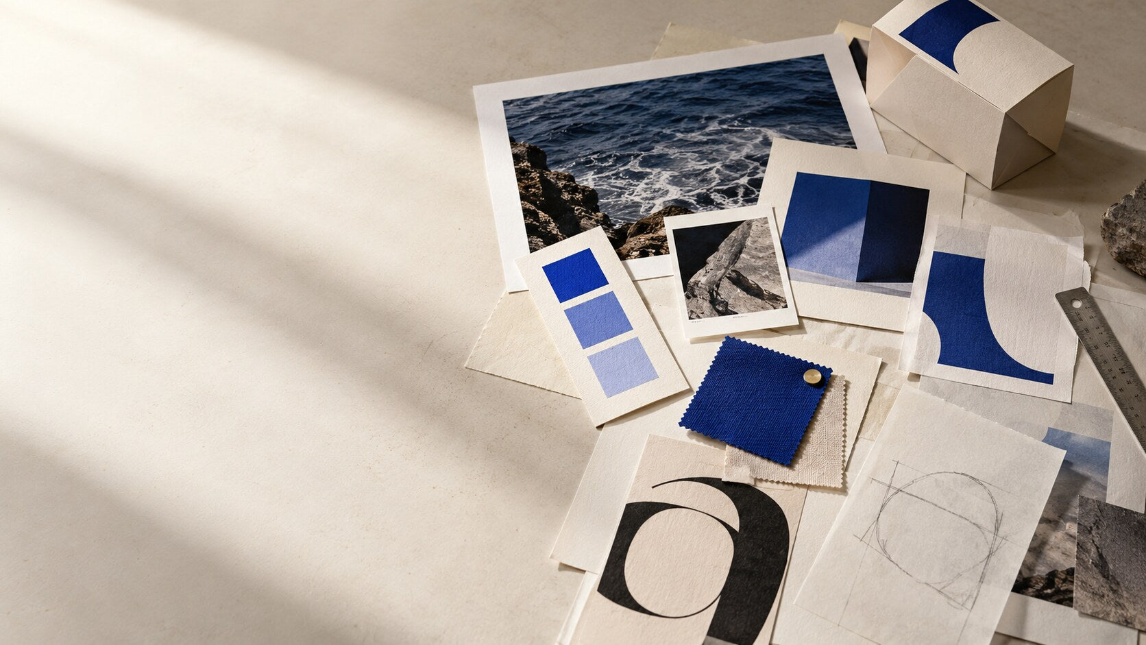 Printed identity directions, paper samples and cobalt swatches arranged for review