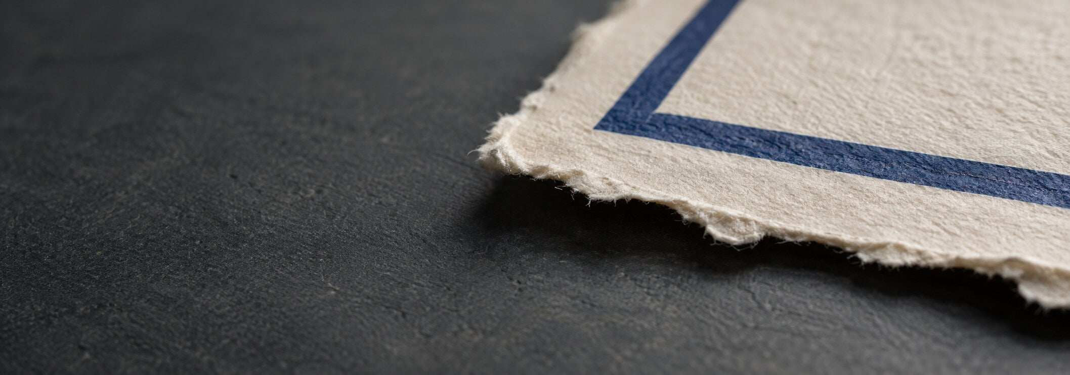 Deckle edge paper carrying a crisp cobalt printed frame
